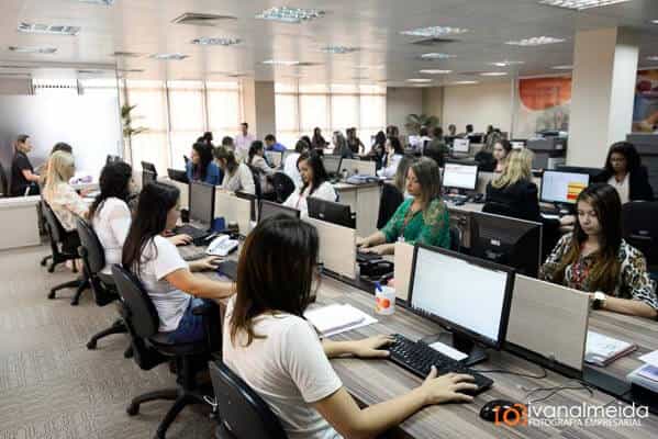 Fotografia de equipe trabalhando em ambiente de atendimento.
