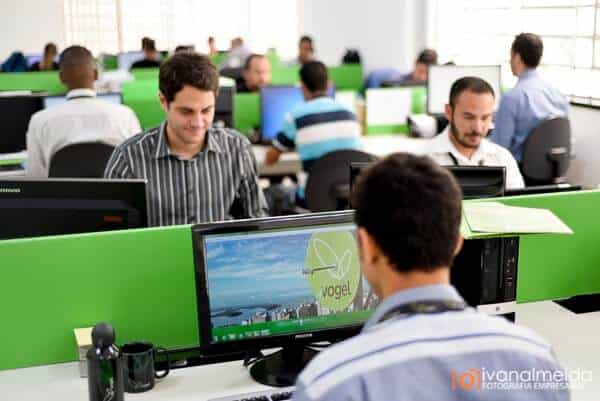 Fotografia de equipe trabalhando em computadores no escritório.