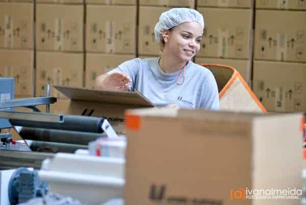 Fotografia de profissional trabalhando com caixas em estoque.